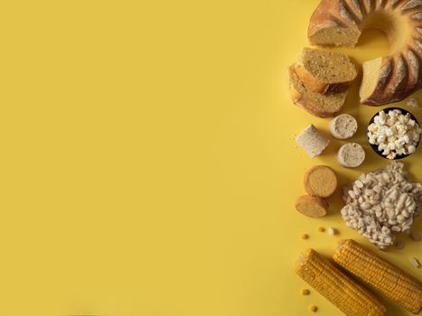 Festa Junina traditional food background,copy space for text. Delicious sweets for Brazilian Festa Junina Party: cornmeal cake Bolo de Fuba, corn cookies,popcorn,peanut candy Pacoca, corn ear top view