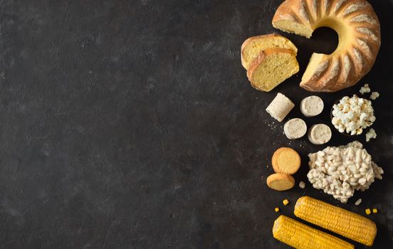 Festa Junina traditional food background,copy space for text. Delicious sweets for Brazilian Festa Junina Party: cornmeal cake Bolo de Fuba, corn cookies,popcorn,peanut candy Pacoca, corn ear top view