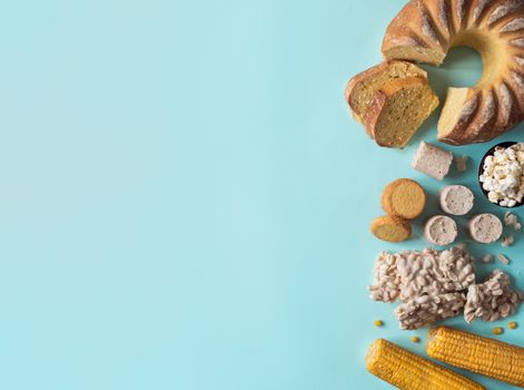 Festa Junina traditional food background,copy space for text. Delicious sweets for Brazilian Festa Junina Party: cornmeal cake Bolo de Fuba, corn cookies,popcorn,peanut candy Pacoca, corn ear top view