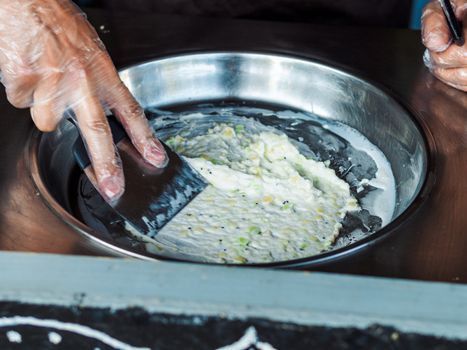 Making rolled ice cream. Man hands making kiwi and banana Thay style natural ice cream