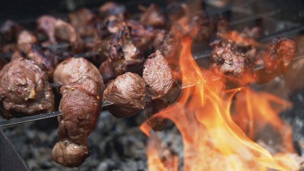 Preparing Shish Kebabs or shashlik on Skewers over a Fire outdoor. Raw meat is cooked on charcoal grill. Copy space. Banner