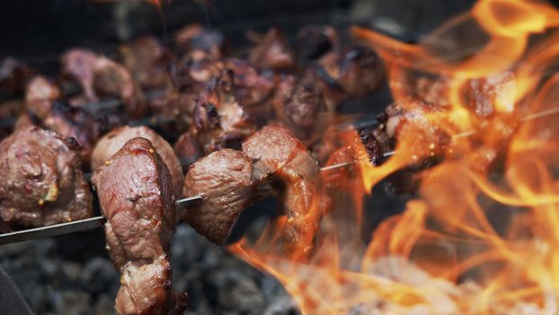 Preparing Shish Kebabs on Skewers over a Fire outdoors. Raw meat is cooked on charcoal grill. Copy space. Banner