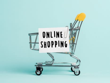 Shopping cart and text online shopping on white paper note list. Online shopping concept on blue background.
