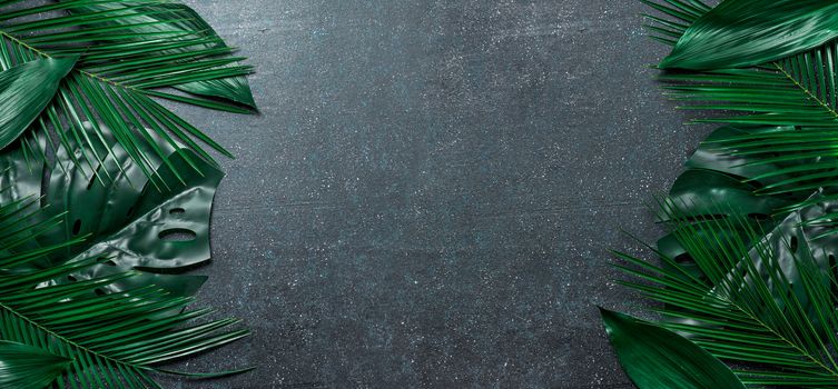 Palm leaves on dark blue background. Tropical leaves top view or flat lay. Copy space for text or design. Horizontal banner. Tropical palm leave, jungle leave floral pattern background