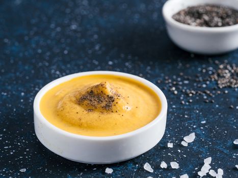 Creamy Cheddar sauce with chia seeds on dark background.Ideas and recipe for healthy diet or vegan food.Homemade Chia Cheeze Sauce for snacks,tacos,nachos,dipping,mac-n-cheese,base for pizza.Copyspace