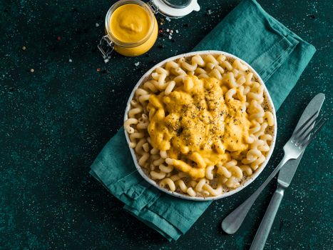 Pasta with vegan creamy chia cheddar sauce on gray background. Ideas and recipe for healthy diet or vegan food. Dish with homemade plant based Chia Cheeze Sauce. Copy space
