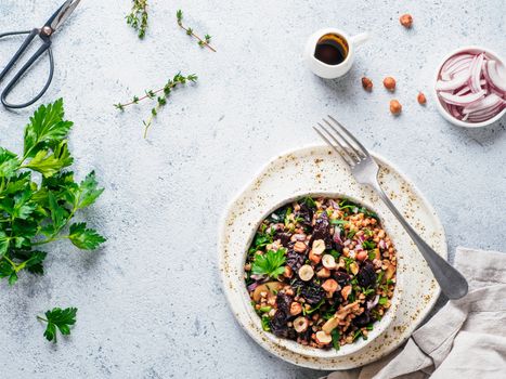 Warm buckwheat and beetroot salad on gray background. Vegetarian diet idea and recipe -salad with beetroot, buckwheat, mushrooms, onion, fresh herbs,hazelnut. Top view or flat-lay. Copy space for text