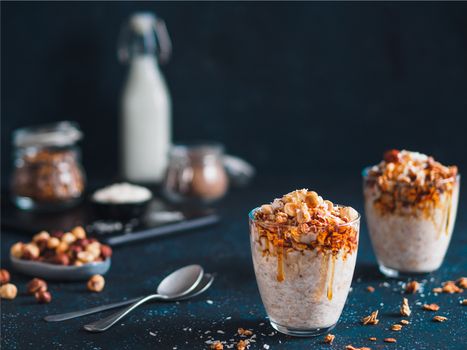 Gingerbread coconut overnight oatmeal served with granola,pecan,honey.Recipe and idea healthy vegan breakfast - plant-based milk overnight oats with chia and gingerbread spices cinnamon, nutmeg,ginger