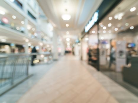 Shopping mall blur background with bokeh. Blurred hall of shopping mall with customers as background. Copy space