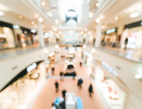 Shopping mall blur background with bokeh. Blurred hall of shopping mall with customers as background. Copy space