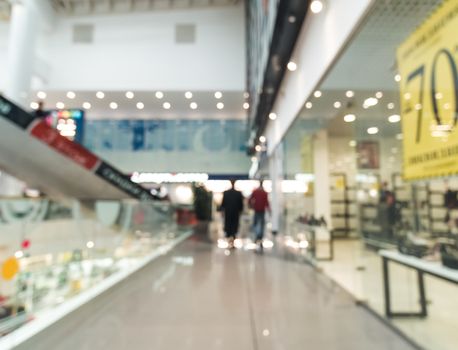 Shopping mall blur background with bokeh. Blurred hall of shopping mall with customers as background. Copy space