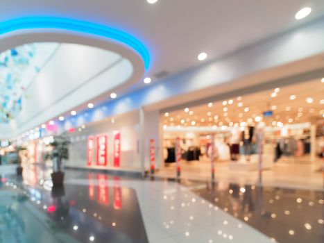 Shopping mall blur background with bokeh. Abstract blurred entrance area of clothes and shoes store. Copy space
