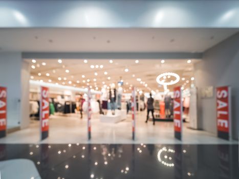 Shopping mall blur background with bokeh. Abstract blurred entrance area of clothes and shoes store. Copy space