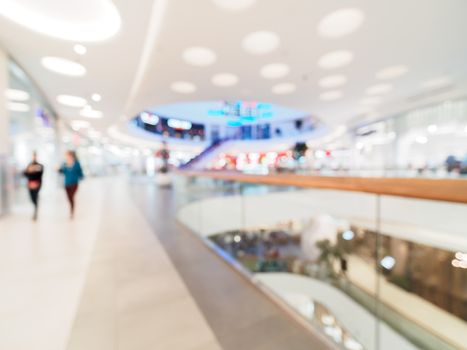 Shopping mall blur background with bokeh. Blurred hall of shopping mall with customers as background. Copy space