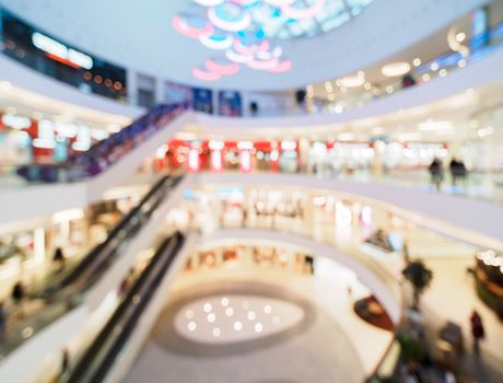 Shopping mall blur background with bokeh. Blurred hall of shopping mall with customers as background. Copy space