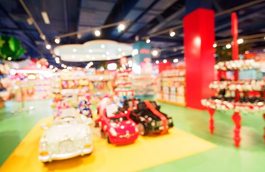 Blurred of kids toy store background with bokhe. shelves with cars and aisle of kids toy shop interior, copy space