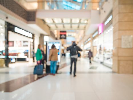 Shopping mall blur background with bokeh. Blurred hall of shopping mall with customers as background. Copy space