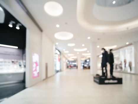 Shopping mall blur background with bokeh. Blurred hall of shopping mall with customers as background. Copy space