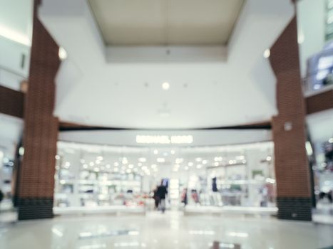 Shopping mall blur background with bokeh. Blurred hall of shopping mall with customers as background. Copy space