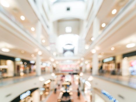 Shopping mall blur background with bokeh. Blurred hall of shopping mall with customers as background. Copy space