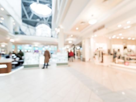 Shopping mall blur background with bokeh. Blurred hall of shopping mall with customers as background. Copy space