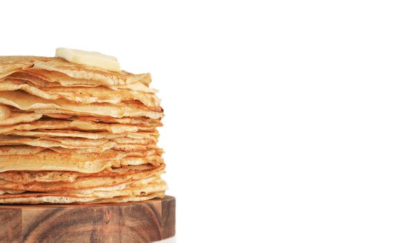 Stack of traditional russian pancakes blini isolated on white background with copy space. Homemade russian thin pancakes blini with butter piece. Russian food, russian kitchen