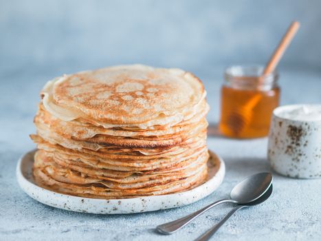 Stack of traditional russian pancakes blini on gray background with copy space. Homemade russian thin pancakes blini. Russian food, russian kitchen