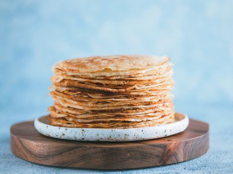 Stack of traditional russian pancakes blini on gray background with copy space. Homemade russian thin pancakes blini. Russian food, russian kitchen