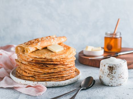 Stack of traditional russian pancakes blini on gray background with copy space. Homemade russian thin pancakes blini. Russian food, russian kitchen