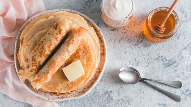 Stack of traditional russian pancakes blini on gray background with copy space. Homemade russian thin pancakes blini. Russian food, russian kitchen. Top view or flat lay