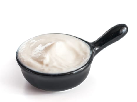 Beautiful greek yogurt or sour cream in black bowl, isolated on white background with clipping path. Copy space for text