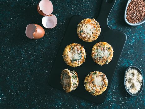 Buckwheat casserole with spinach,carrot,parmesan.Baked eggs with buckwheat,vegetables and cheese.Ideas and recipes healthy easy breakfast,lunch,kids meal,snack - vegetables muffins.Copy space.Top view