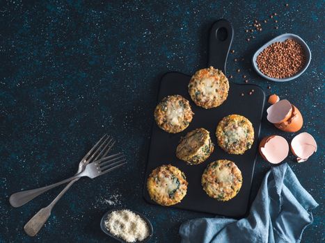 Buckwheat casserole with spinach,carrot,parmesan.Baked eggs with buckwheat,vegetables and cheese.Ideas and recipes healthy easy breakfast,lunch,kids meal,snack - vegetables muffins.Copy space.Top view