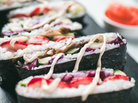 Vegan sushi sandwich onigirazu with vegetables. Healthy dinner recipe and idea. Colorful japan sandwich onigirazu with red cabbage, radish, cucumber, mushrooms. Trend food. Close up, shallow DOF