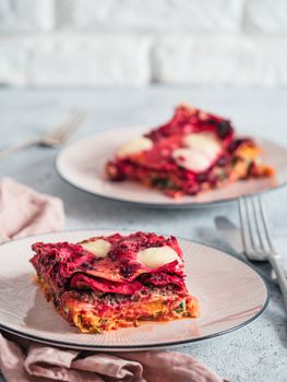 Vegetable Packed Rainbow Lasagne on pink plate. Ideas and recipes for healthy vegetarian dinner or lunch. Lasagne with beetroot, pumpkin, mushrooms, ricotta, spinach, mozarella. Copy space for text.