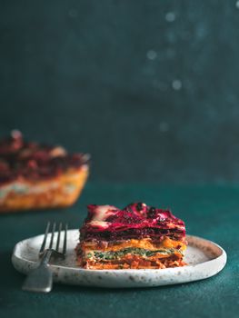 Vegetable Packed Rainbow lasagne on green background.Ideas and recipes for healthy vegetarian dinner or lunch.Lasagne with beetroot, pumpkin, mushrooms, ricotta, spinach, mozarella.Copy space for text