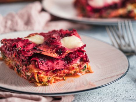 Vegetable Packed Rainbow Lasagne on pink plate. Ideas and recipes for healthy vegetarian dinner or lunch. Lasagne with beetroot, pumpkin, mushrooms, ricotta, spinach, mozarella