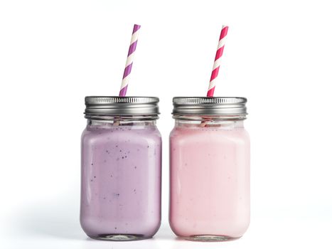 Strawberry and blueberry smoothie in mason jar glass. Isolated on white with clipping path.