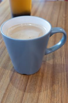 Coffee with milk in mug on table