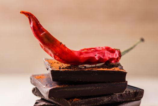 Red chili peppers on the chocolate stack with cayenne powder.