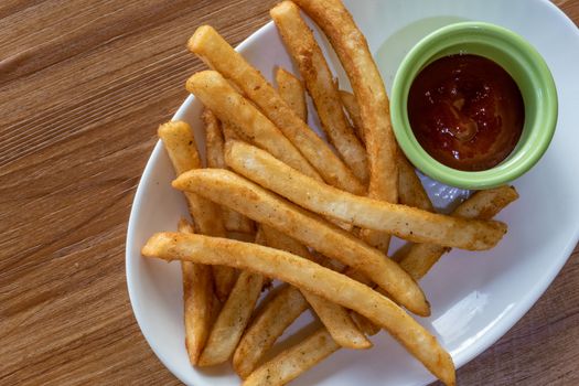 French fries and ketchup on plate, shot from above