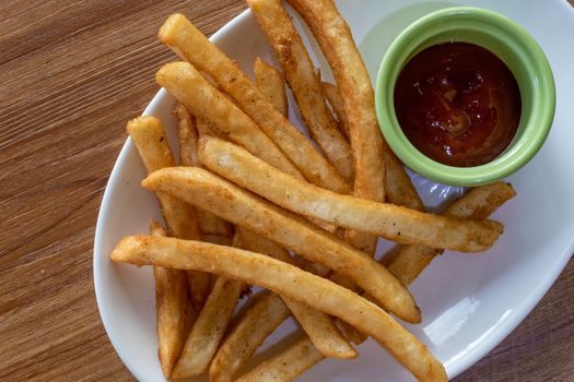 French fries and ketchup on plate, shot from above