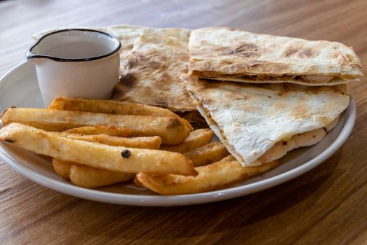 Quesadilla and french fries on plate