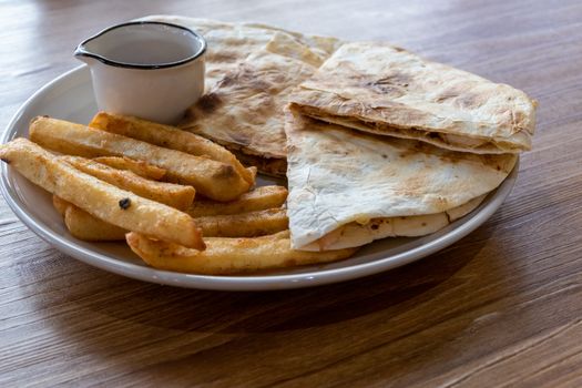 Quesadilla and french fries on plate