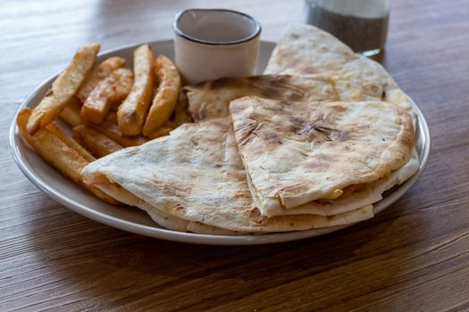 Quesadilla and french fries on plate