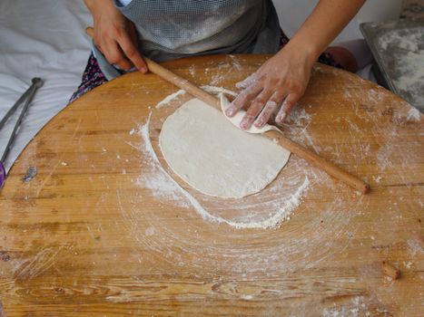 woman who makes "bazlama" and "yufka". raw dough opens with rolling pin