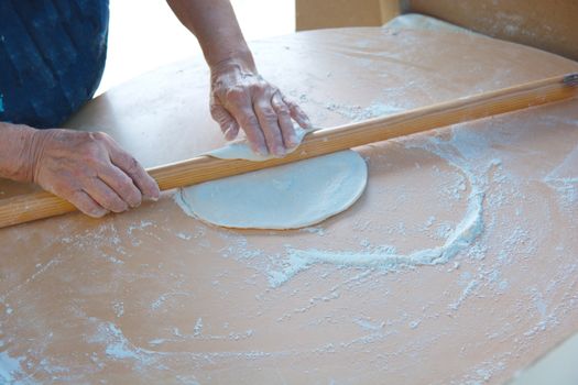 woman who makes "bazlama" and "yufka". raw dough opens with rolling pin