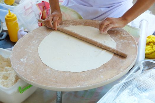 woman who makes "bazlama" and "yufka". raw dough opens with rolling pin