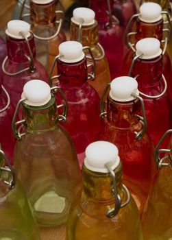 Close up mixed color glass bottles with retro vintage sealing cap on retail display