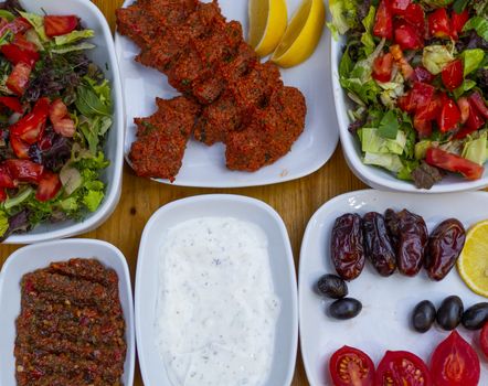 appetizer table. The background consisting of salad, yogurt, olives, raw meatballs and appetizers.  Organic food background. isolated wooden background. "haydari"